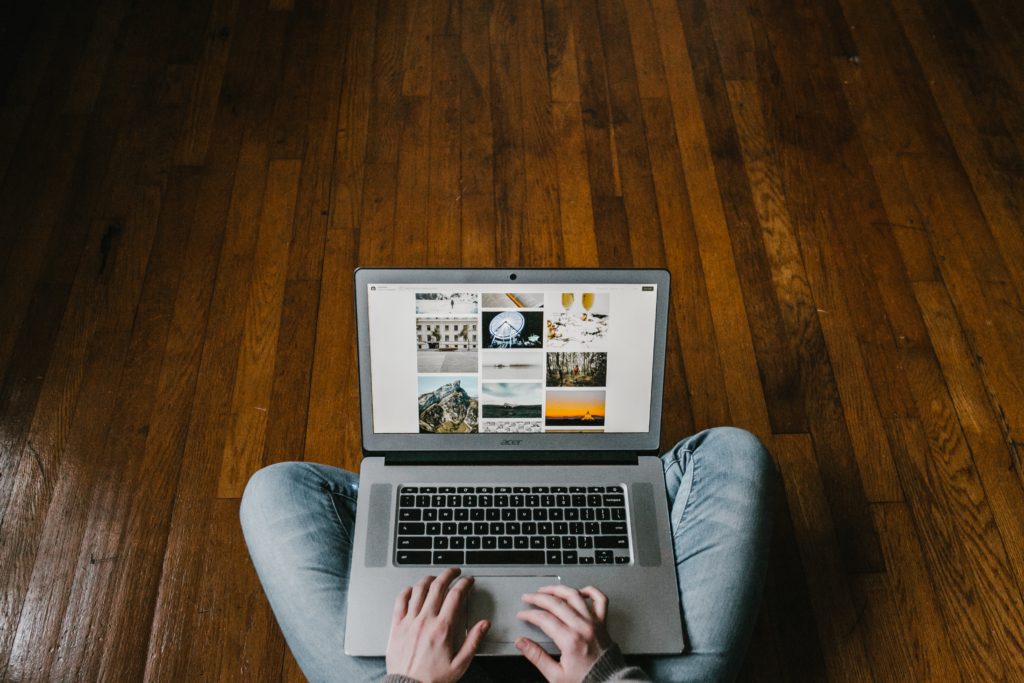 person sitting on wood floor with laptop