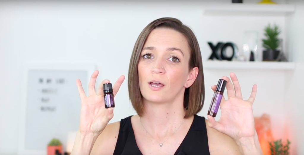 Tara holding Console Essential Oils in each hand one bottle and one rollerball.