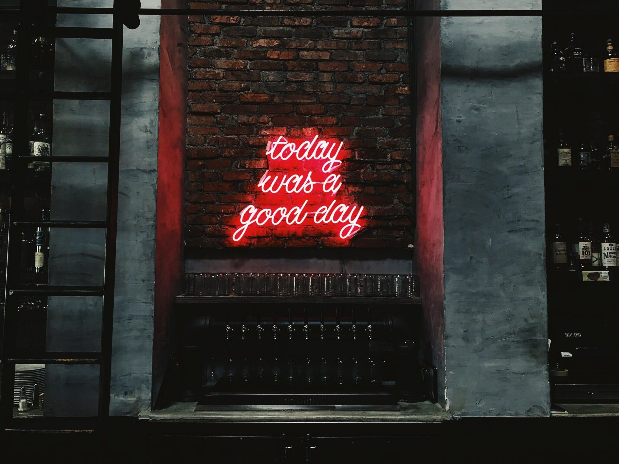 red neon sign on brick wall that says "today was a good day"