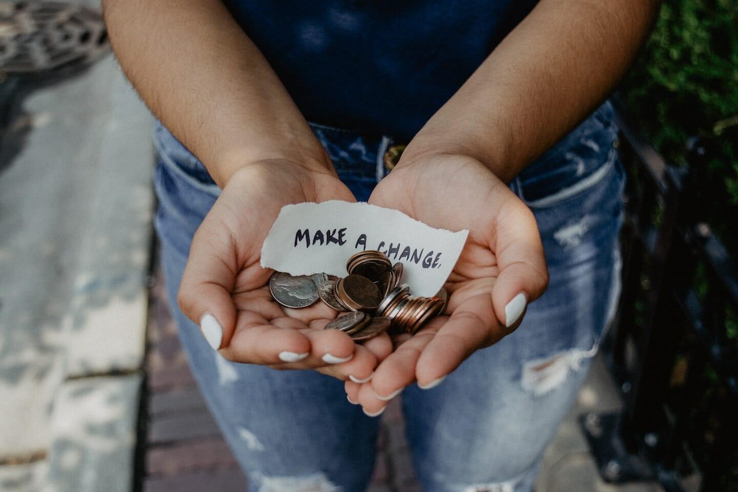 hands full of change with a piece of paper that says "make a change"