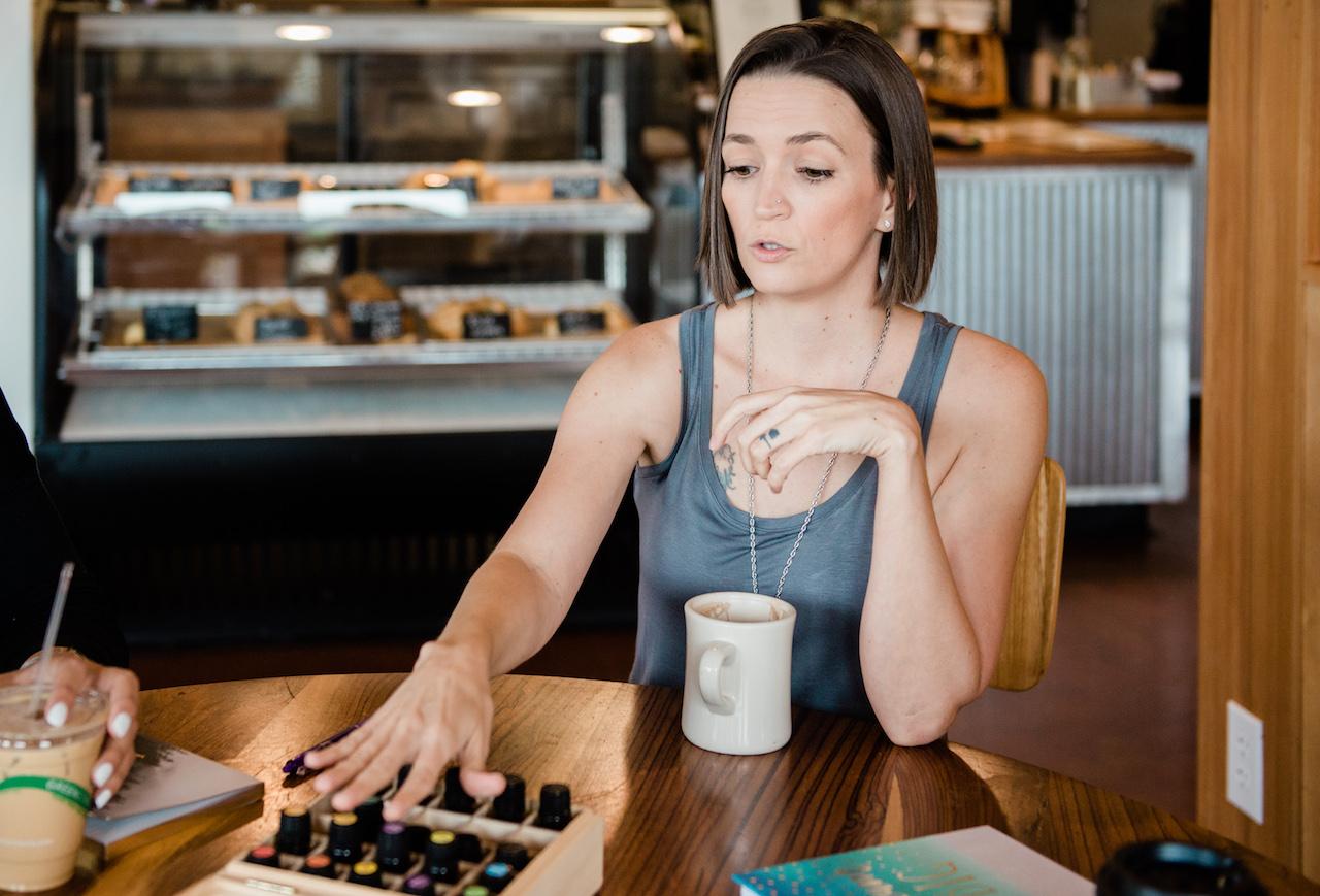 Tarain gray tank top explaining doTERRA oils in coffee shop