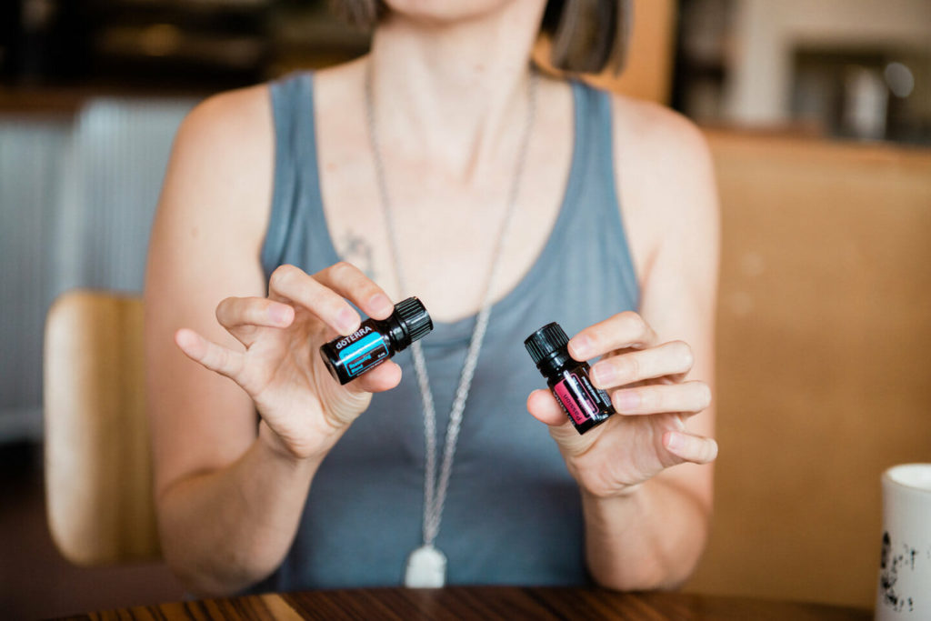 Tara holding 2 bottles of essential oils