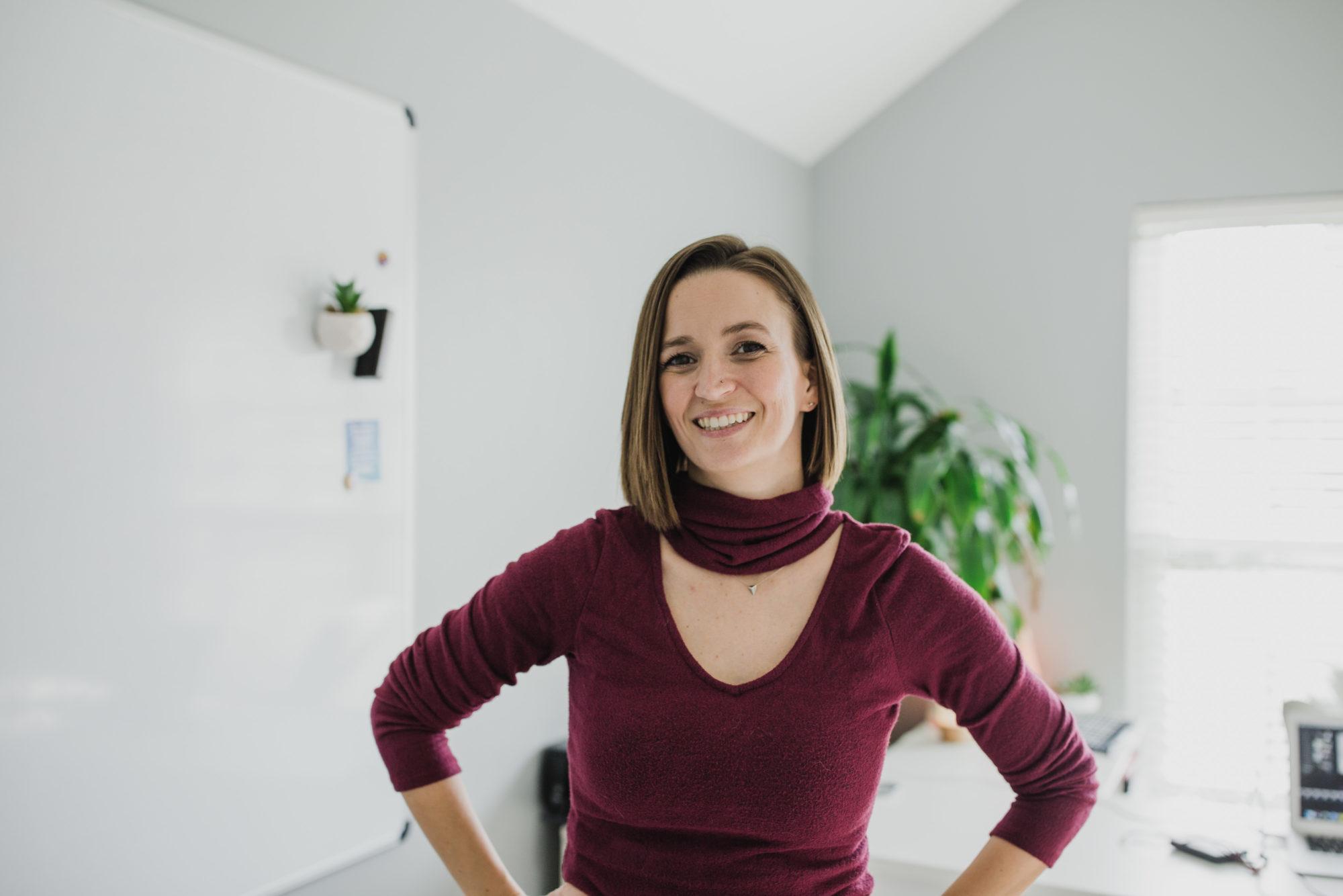 Tara wearing a maroon 3/4 sleeve shirt in home office smiling