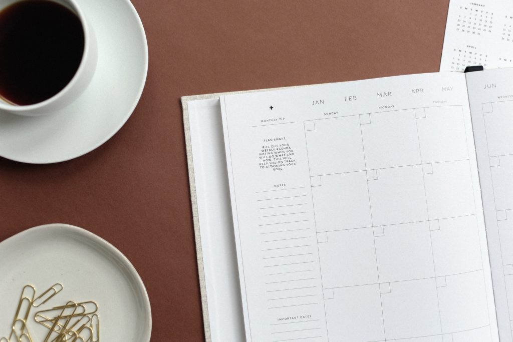 Monthly calendar with coffee and paper clips beside it