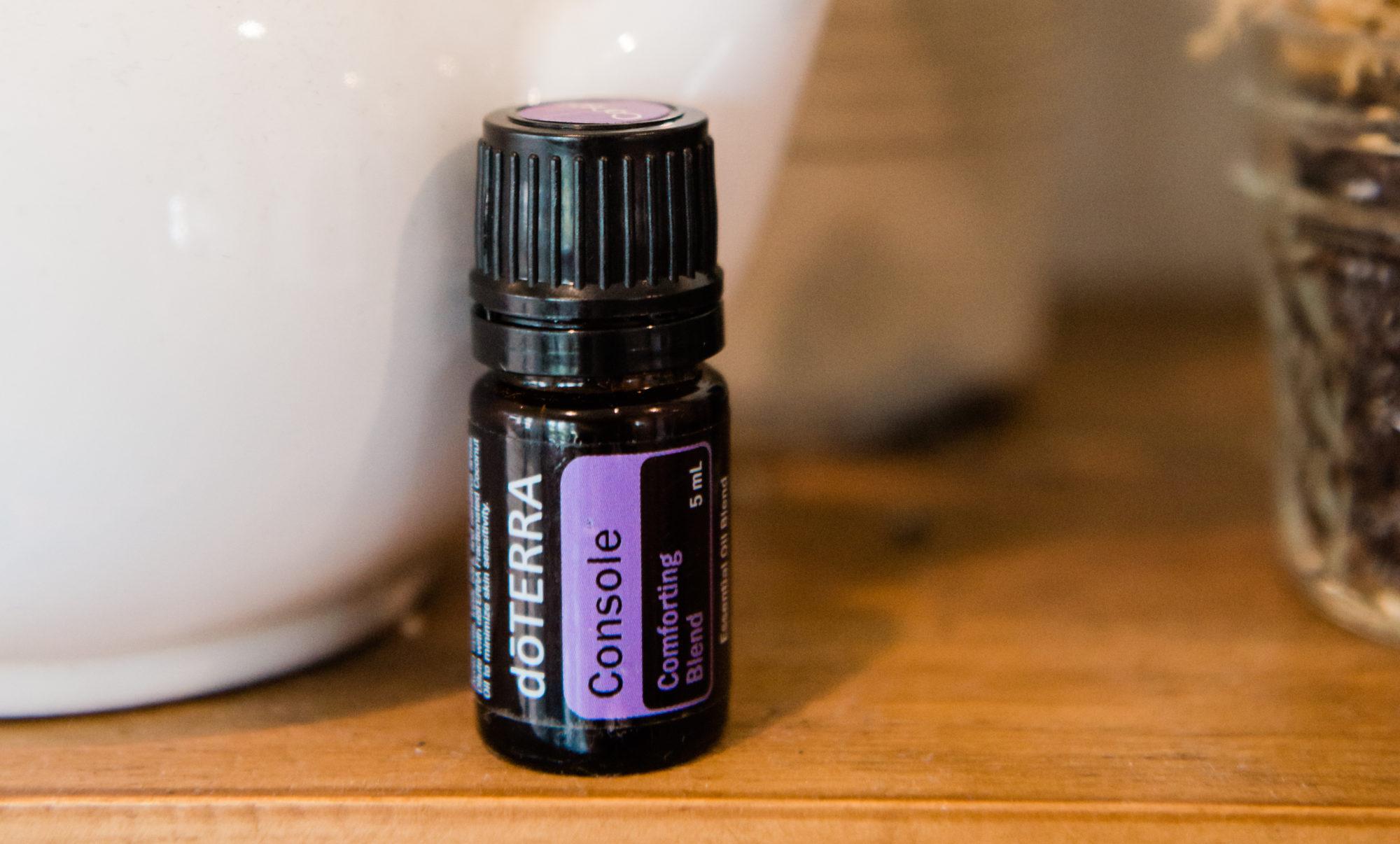 doTERRA bottle of Console Essential Oil on wood table