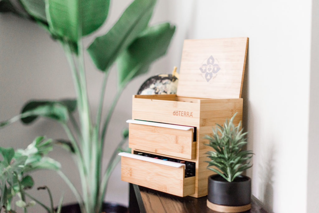 Wooden doTERRA box of oils with foliage in the foreground and background