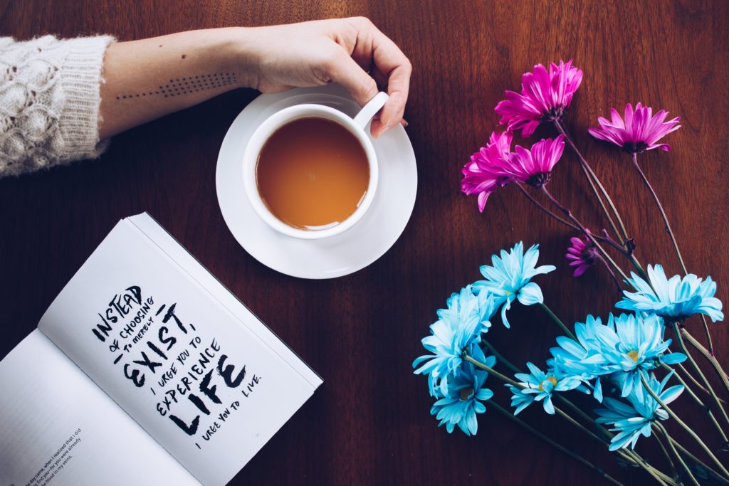 girls arm on table with coffee and book