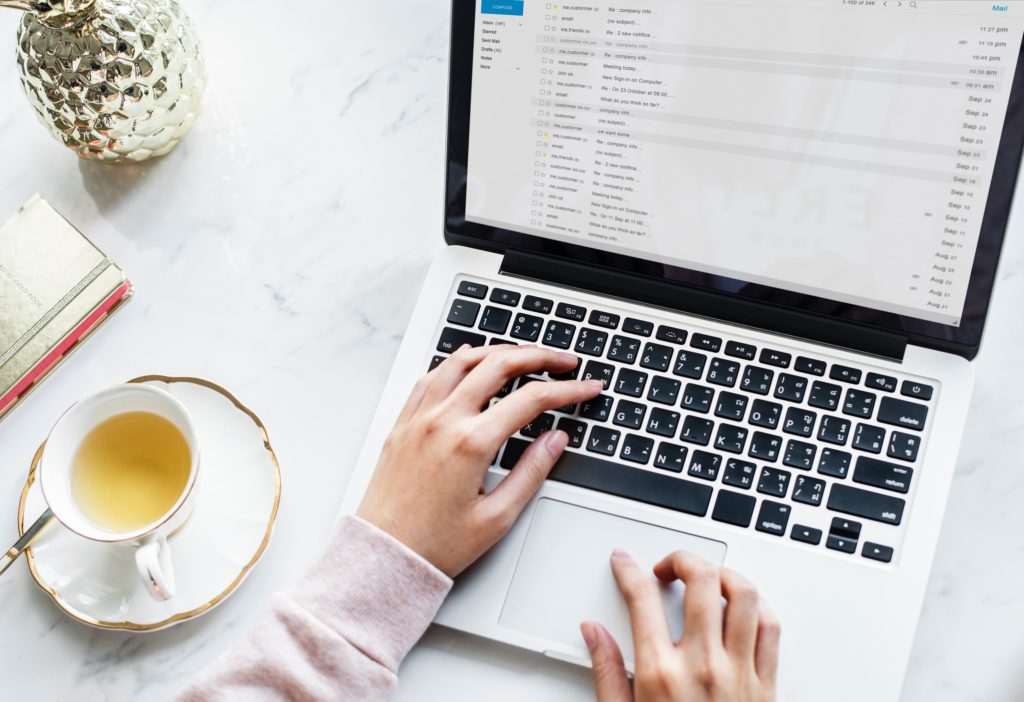 Woman working on laptop with tea