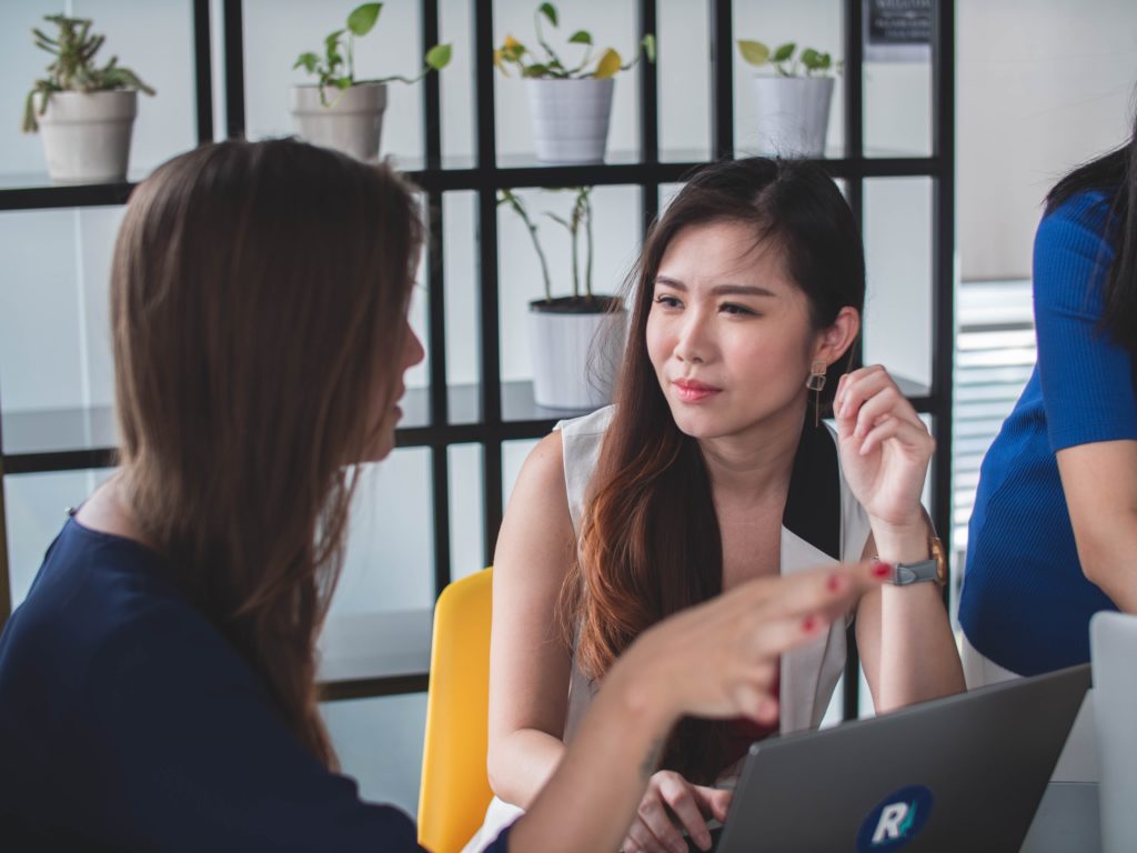 woman talking to another woman who looks critical