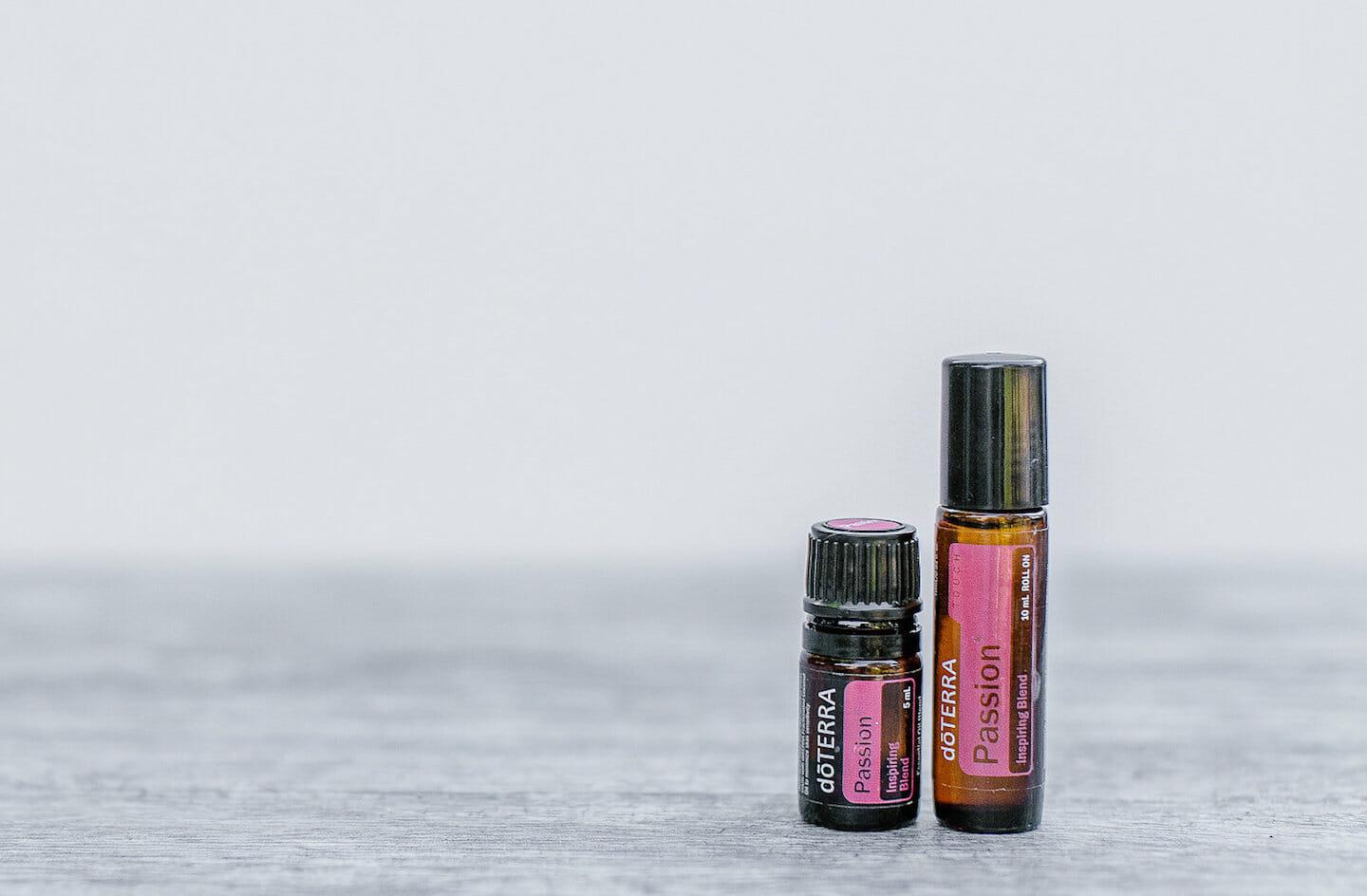 Passion Essential Oil 15ml bottle and rollerbottle side by side on table