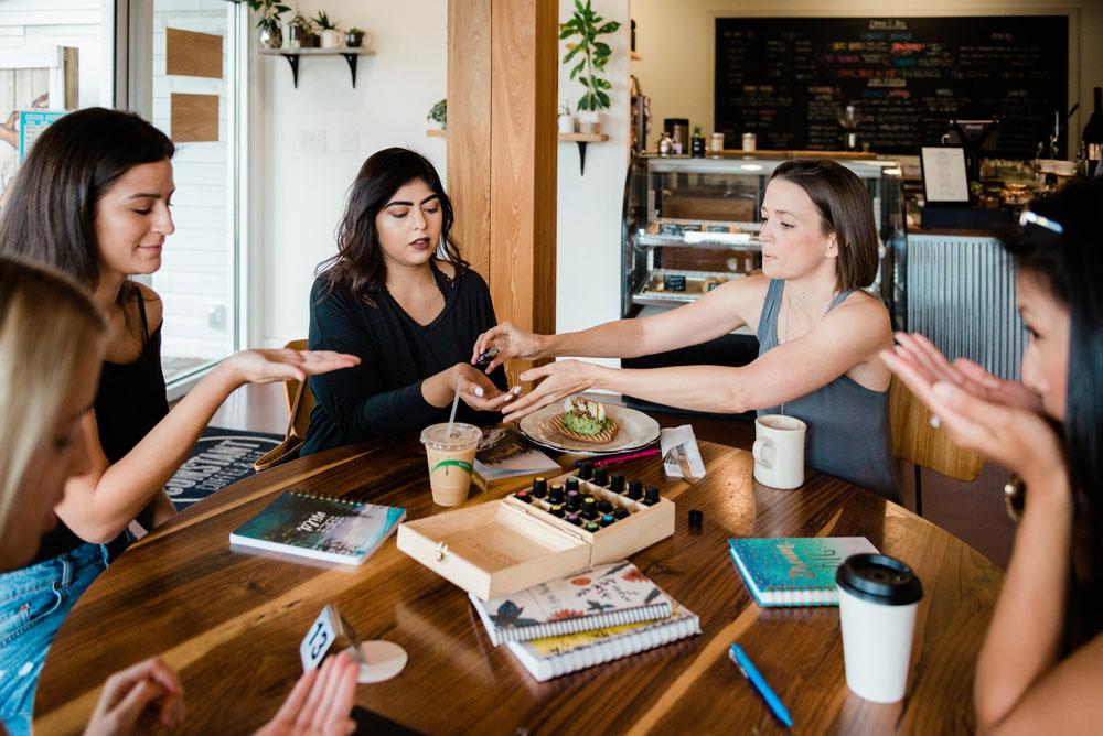 women sitting with Tara in coffee shop sharing oils