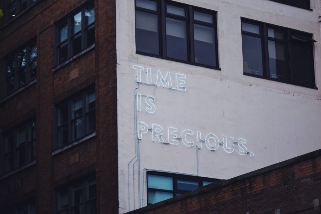 neon sign that says time is precious