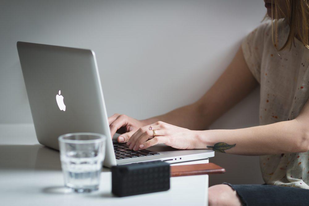 Woman working on silver Apple laptop