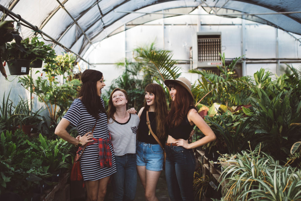 women hanging out in greenhouse