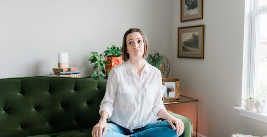 Tara sitting on a couch looking uncertain