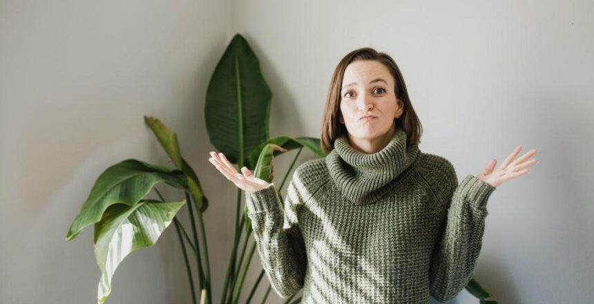 Tara wearing green sweater with hands up in uncertainty