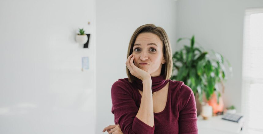 Tara in maroon shirt looking unsure in minimalist room