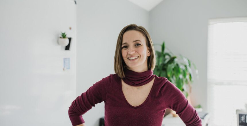 Tara wearing a maroon 3/4 sleeve shirt in home office smiling
