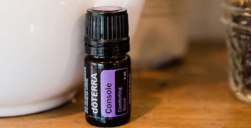 doTERRA bottle of Console Essential Oil on wood table