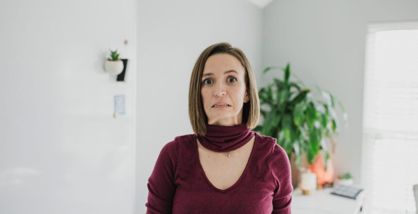 Tara wearing maroon long sleeve v-neck looking overwhelmed