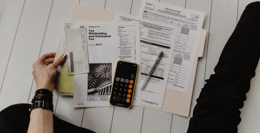woman sitting on floor looking over papers for taxes