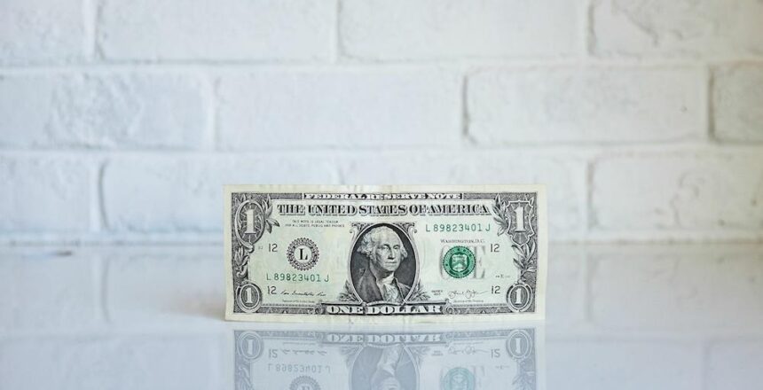 a single dollar bill on white counter with white brick background