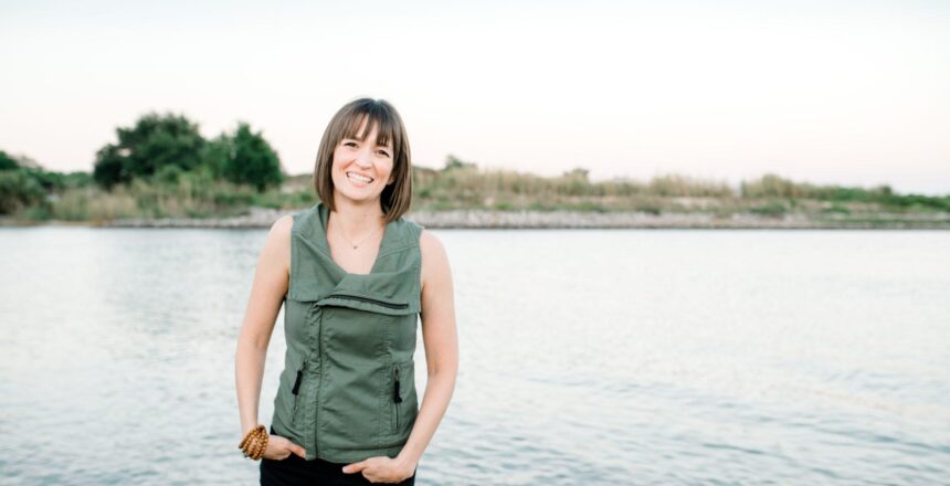 tara standing smiling at the edge of a body of water