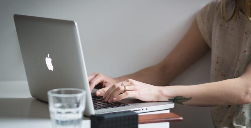 Woman working on silver Apple laptop